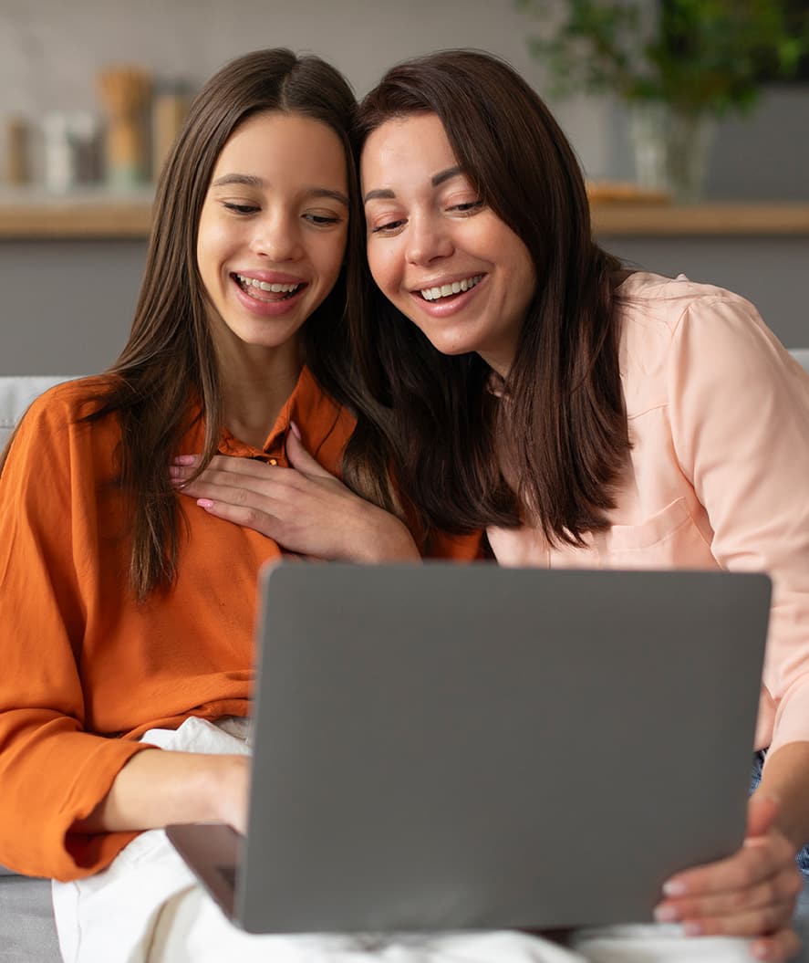 Happy mother and teen daughter looking at laptop looking at college admissions support